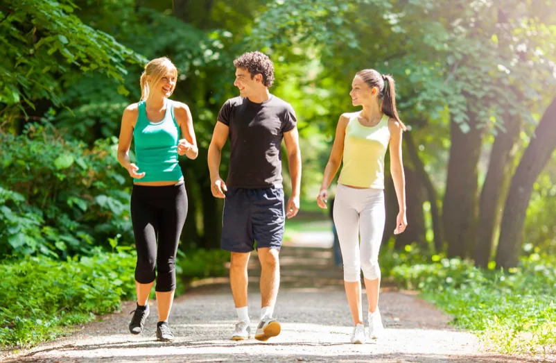 Neighbors on a group fitness walk along a wooded Woodbury trail