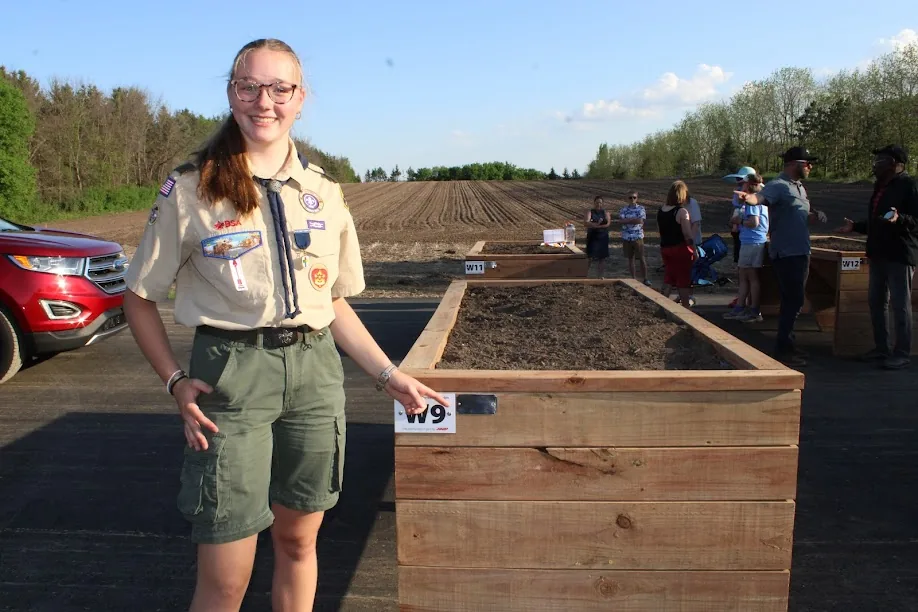 A Scout leading a project at the community garden raised beds