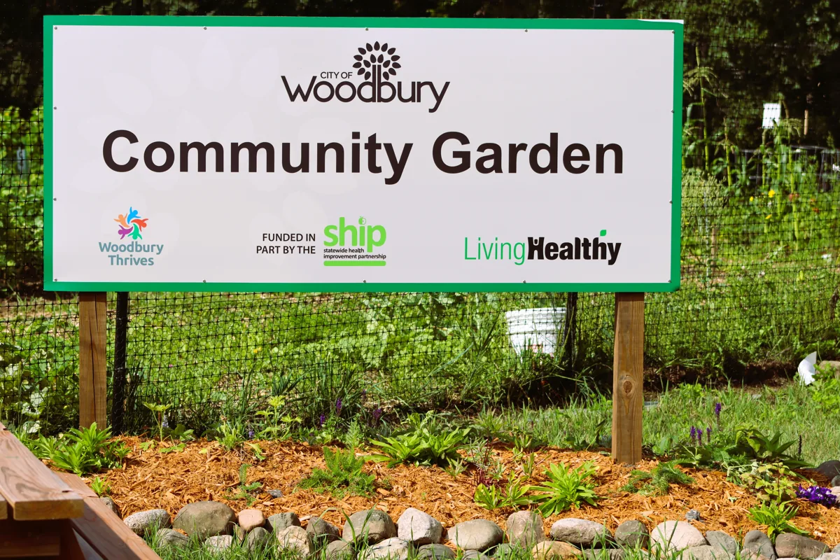 Flowers and the Woodbury Community Garden sign in bloom
