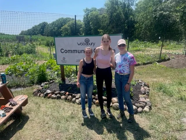 Woodbury Thrives neighbors gathered together at the community garden sign