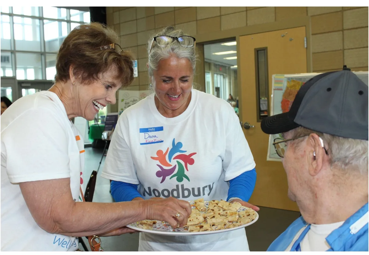 Woodbury Thrives volunteers sharing a plate of food with a neighbor at a community meal